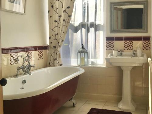 a bathroom with a tub and a sink at Ivy Cottage in Skipton