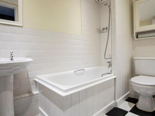 a bathroom with a tub and a toilet and a sink at County House Apartment - 27911 in York