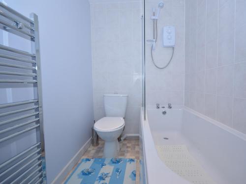 een badkamer met een bad, een toilet en een douche bij Platform One in Paignton