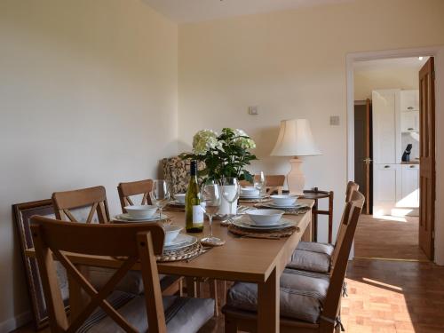 a dining room with a wooden table and chairs at Roundhill in Eydon
