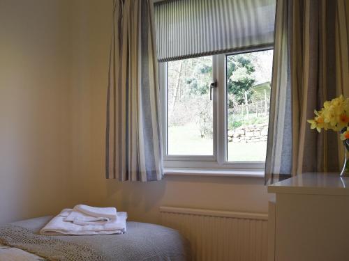 1 dormitorio con ventana y toallas en una cama en Roundhill, en Eydon