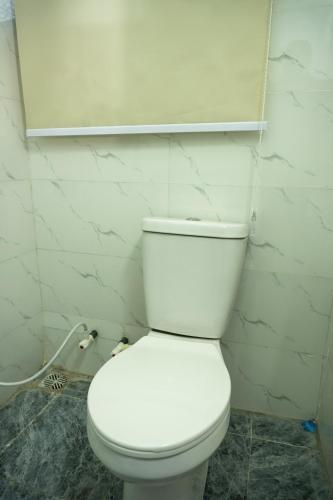 a bathroom with a white toilet in a room at Spectacular 3/4-Bed-Apt With 24hrs Power And FAST Wi-Fi in Amuwo