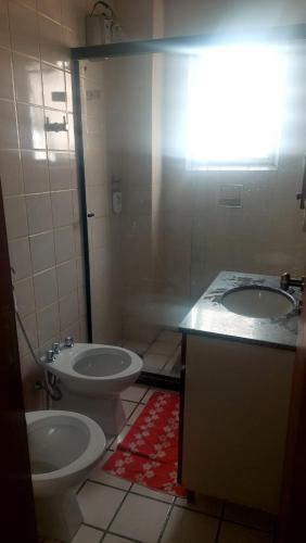 a bathroom with two sinks and a toilet at Espaço ALA Minas in São Lourenço