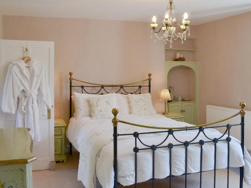 - une chambre dotée d'un lit avec des draps blancs et un lustre dans l'établissement Maidenland, à Saint Kew