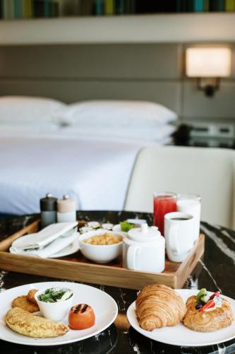 a tray of food on a table with plates of food at Courtyard by Marriott Navi Mumbai in Navi Mumbai