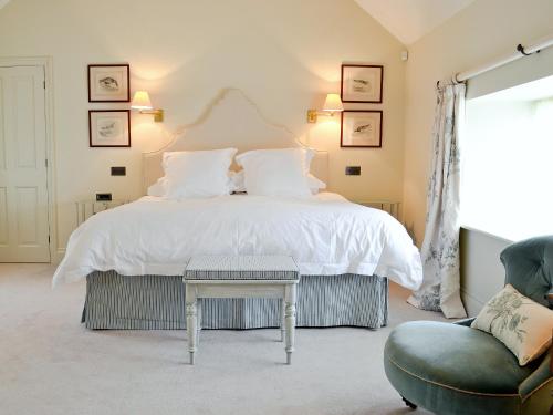 a bedroom with a large bed and a chair at Marsh Barn in Brancaster