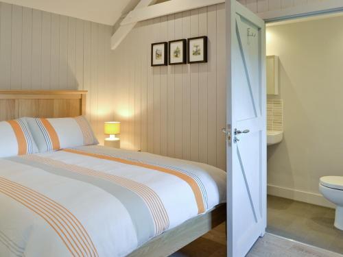 ein Schlafzimmer mit einem Bett und einem WC in der Unterkunft Blackberry Lodge in Cheddar
