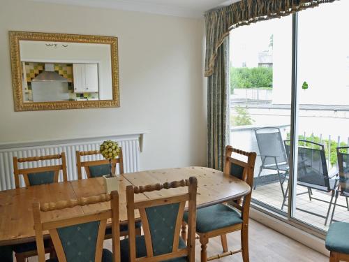 a dining room with a table and chairs and a large window at Waterside in Bowness-on-Windermere