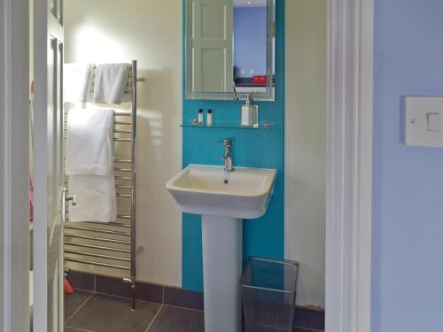 a bathroom with a sink and a mirror at Granary Cottage in Bentley