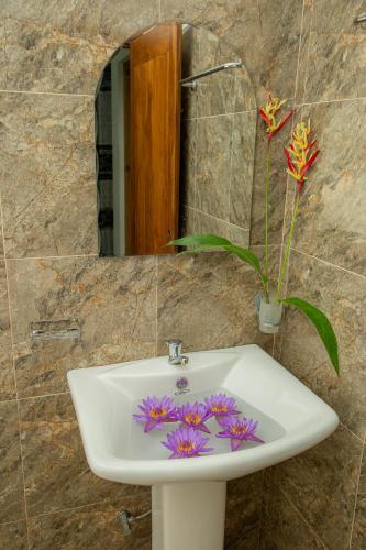 a sink with purple flowers on it in a bathroom at Villa 146 Dickwella in Batigama