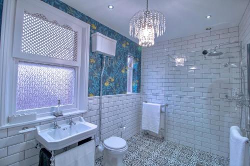 ein Bad mit einem Waschbecken, einem WC und einem Fenster in der Unterkunft Fabulously Unique 3BD Home Sunderland in Sunderland