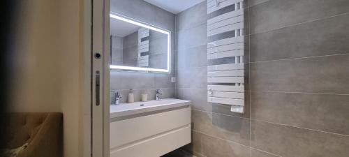 La salle de bains est pourvue d'un lavabo et d'un miroir. dans l'établissement Appartement de luxe Eze village vue mer avec piscine, à Èze