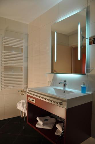 a bathroom with a sink and a mirror at Hotel Lindenhof Bad Schandau in Bad Schandau