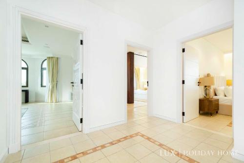 a living room with white walls and a large doorway at LUX The White Palm Villa in Dubai