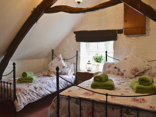 a bedroom with two beds with green towels on them at Bwthyn Barri in Sarnau