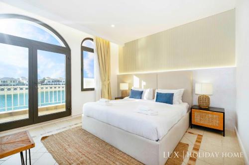 a bedroom with a large bed and a large window at LUX The White Palm Villa in Dubai