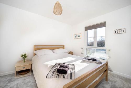 Un dormitorio con una gran cama blanca y una ventana en Immaculate 3 Bedroom Home Barnstaple Devon en Barnstaple
