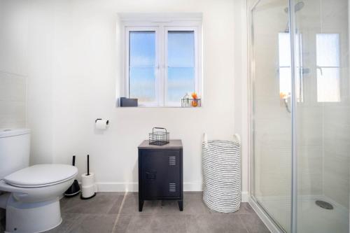 e bagno con servizi igienici e doccia in vetro. di Immaculate 3 Bedroom Home Barnstaple Devon a Barnstaple