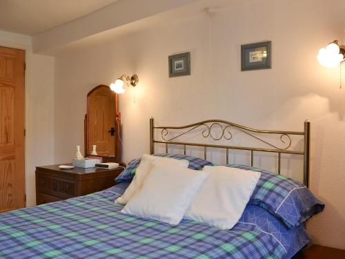 a bedroom with a bed with two pillows on it at Upper Ffinnant in Aber-Brân