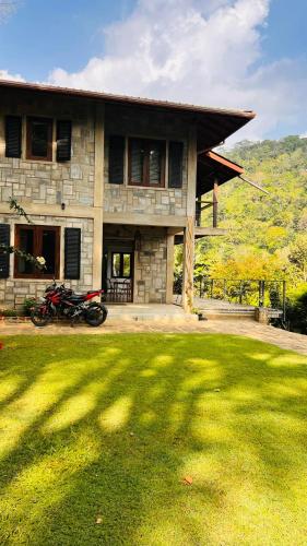 a house with a motorcycle parked in front of it at Benjamin Cottage Haputale in Haputale