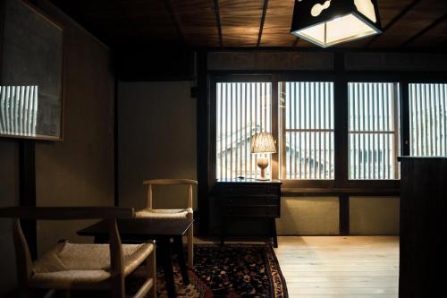 sala de estar con mesa, sillas y ventana en Oito 美しい街並みに佇む喫茶と宿, en Tamba-sasayama