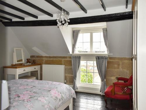 - une chambre avec un lit, un bureau et une fenêtre dans l'établissement White Cottage, à Whitby