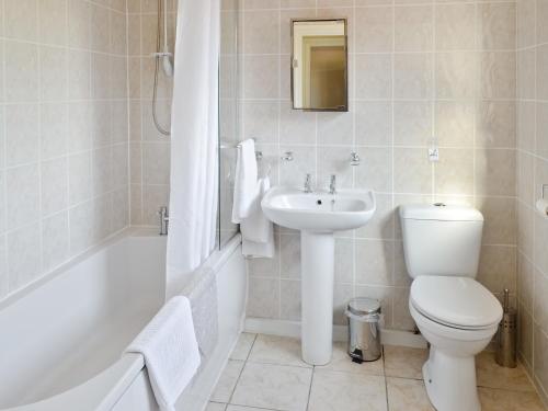 a bathroom with a toilet and a sink and a bath tub at Weetwood Lodge in Kelsall