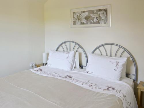 białe łóżko z 2 białymi poduszkami w obiekcie Weetwood Lodge w mieście Kelsall