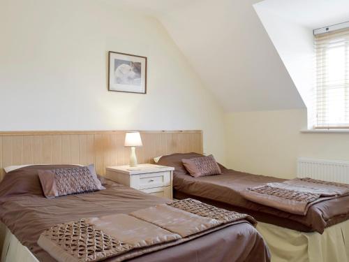 um quarto com duas camas e um candeeiro em Dormers em Leiston
