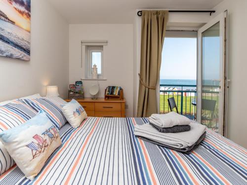a bedroom with a bed with a view of the ocean at 8 Belvedere Court in Paignton