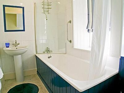 a bathroom with a tub and a sink and a shower at Glencoe Cottage in Glencoe