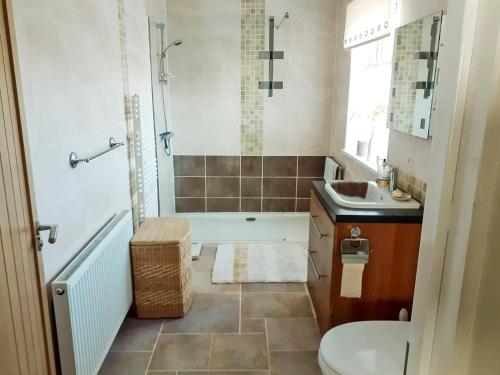 a bathroom with a tub and a toilet and a sink at Green View in Churston Ferrers