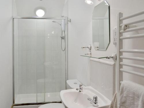 a white bathroom with a shower and a sink at The Granary Barn - 25589 in North Willingham