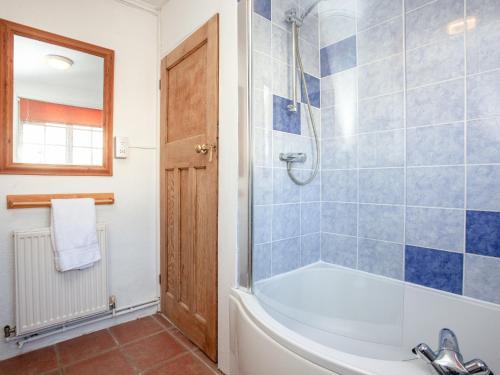 a bathroom with a bath tub and a shower at Bowjy Cottage in Cubert