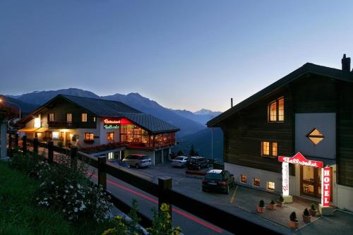 a group of buildings with mountains in the background at Hotel Bellwald in Bellwald