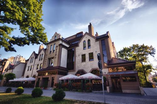 ein Gebäude auf einer Straße mit einem Restaurant davor in der Unterkunft Hotel Silvia Gold Gliwice in Gliwice