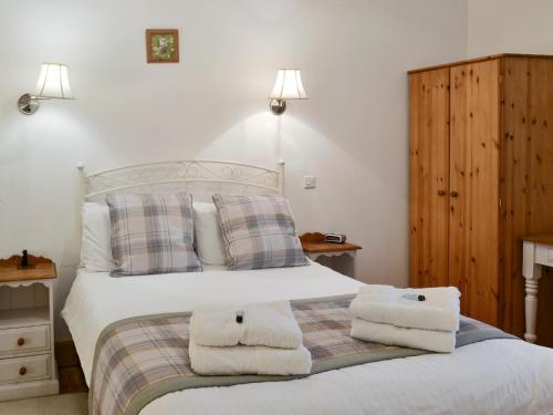 een slaapkamer met een bed met handdoeken erop bij The Hay Barn- 26724 in North Willingham