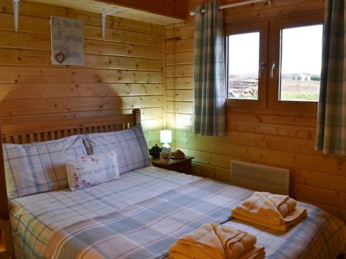 a bedroom with a bed with towels on it at Birdsong Cabin in Breakish