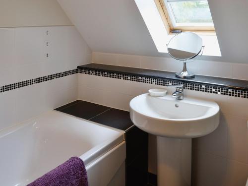 a bathroom with a sink and a mirror at Lime Tree Cottage in Oakley