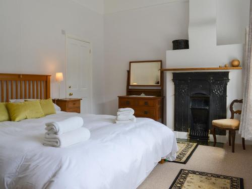 um quarto com uma cama branca e toalhas em The Mistress House em Hunstanton