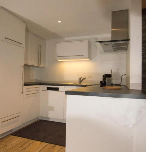 a kitchen with white cabinets and a sink at Residence Bellevue in Zermatt