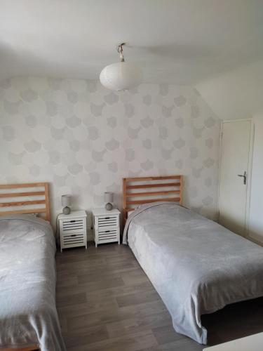 une chambre avec deux lits et deux tables de nuit dans l'établissement La Maison du Verger avec Jardin, à Carnac