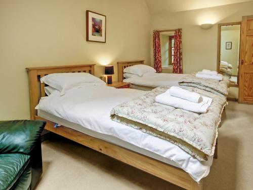 a bedroom with two beds and a couch at Coach House in Ratho