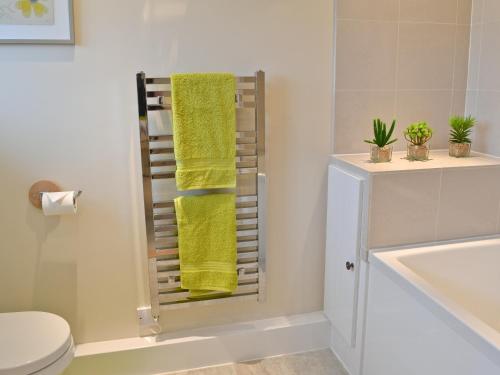 a bathroom with a yellow towel on a towel rack at The Shearing Shed in Peasmarsh