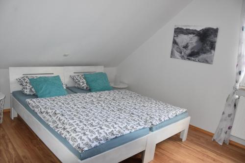 1 dormitorio con 1 cama con almohadas azules en Ferienhaus mit Garten in Nordseenähe, en Langenhorn