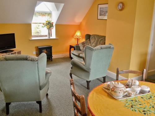 Shipton MoyneにあるWestonbirt Cottageのリビングルーム(ソファ、椅子、テーブル付)