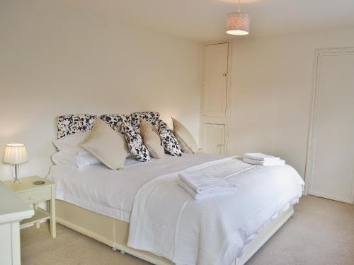 a bedroom with a bed with white sheets and pillows at Midships in Instow