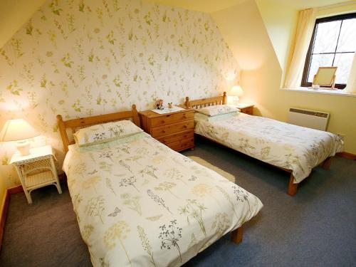 a bedroom with two beds and a window at Hannahs Cottage in Inverasdale