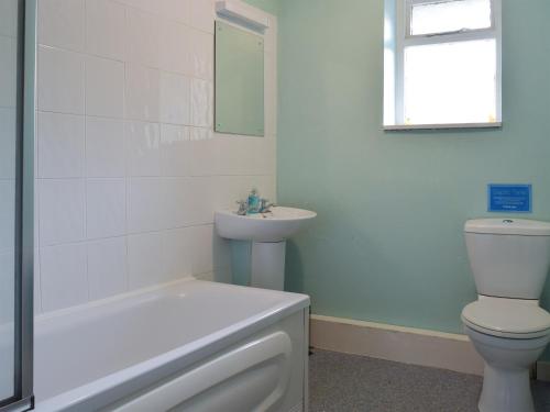 a white bathroom with a toilet and a sink at Popehill Farm Apartment in Johnston