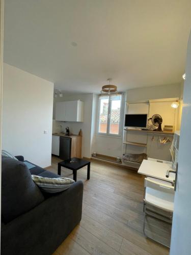 un salon avec un canapé et une cuisine dans l'établissement Petit cocon au cœur du centre historique, à Biot